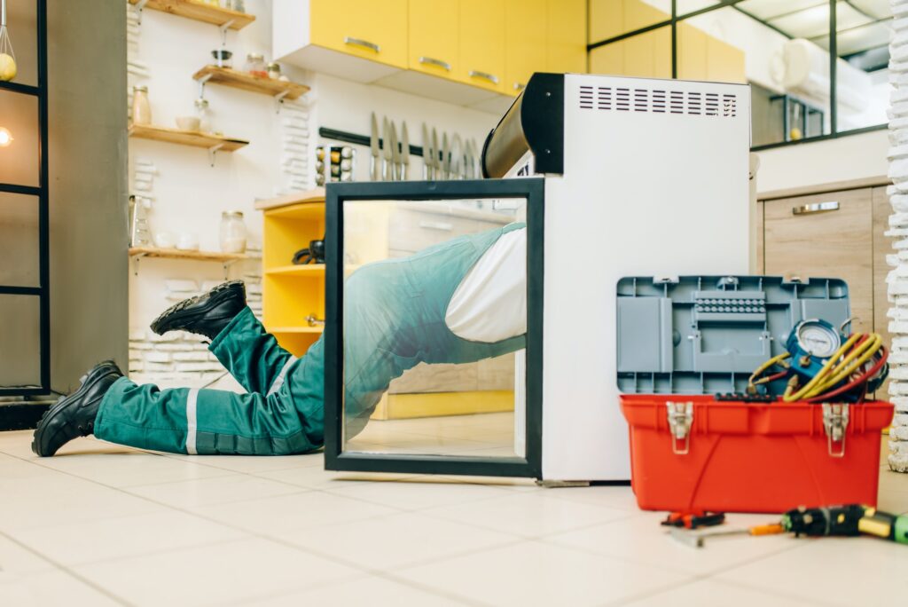 Worker in uniform climbed inside the refrigerator